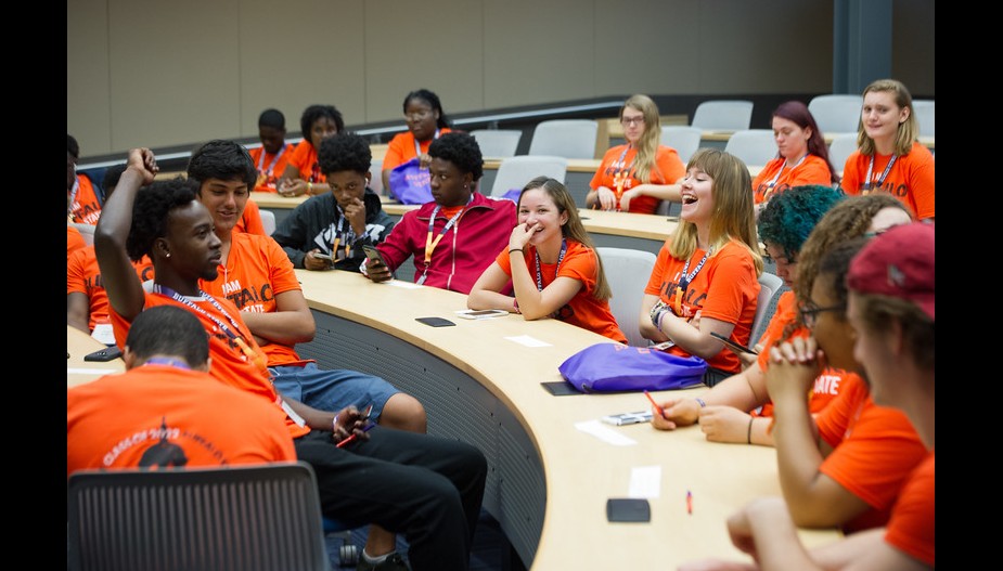 Students socializing during Orientation in a lecture hall