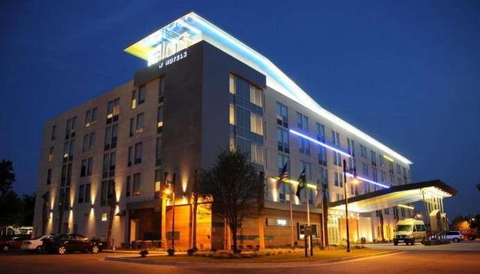 A photo of Airloft Buffalo hotel at night from the front