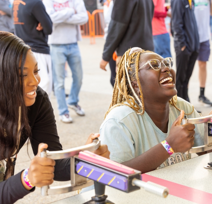 two women smiling enjoying a carnival game