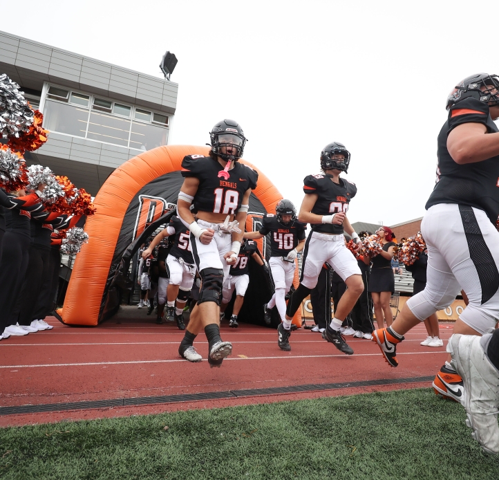 football players running onto field